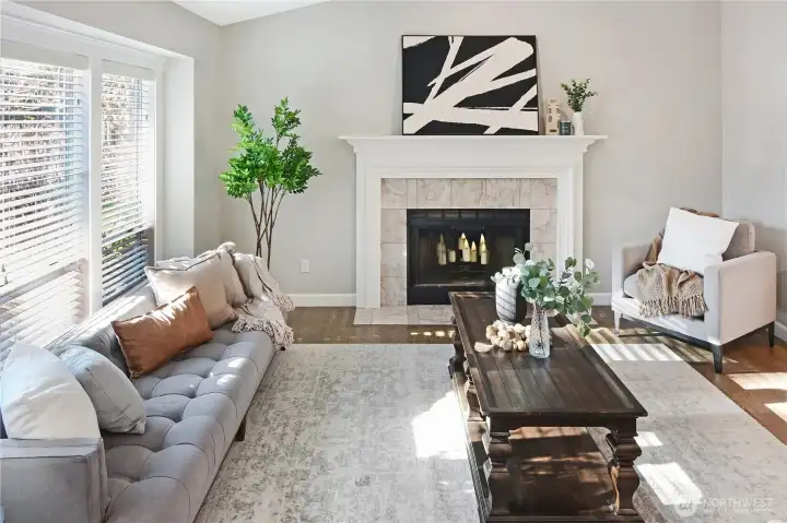 Bright living room featuring a cozy wood fireplace and ample natural light.
