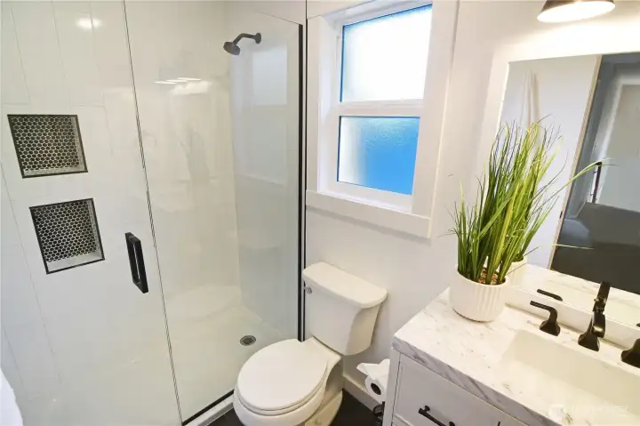 The hall bathroom is super nicely updated with cement look tile floor, penny tile in the shower niches and white porcelain large tiles for limited grout to keep clean.