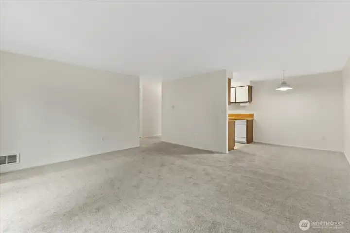 View of the large living room with dining room and kitchen in the background.
