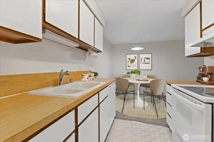 Virtually staged - Gleaming kitchen with a view of the dining room.