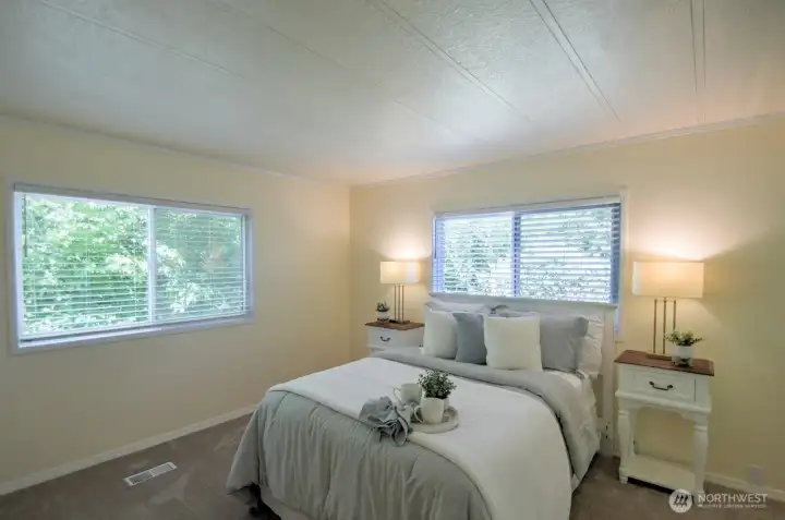 Spacious primary bedroom feels light and airy with window views of the backyard. Wall to wall carpets were recently installed and feel extra cushy under your feet. Spacious primary bedroom feels light and airy with window views of the backyard. Wall to wall carpets were recently installed and feel extra cushy under your feet.