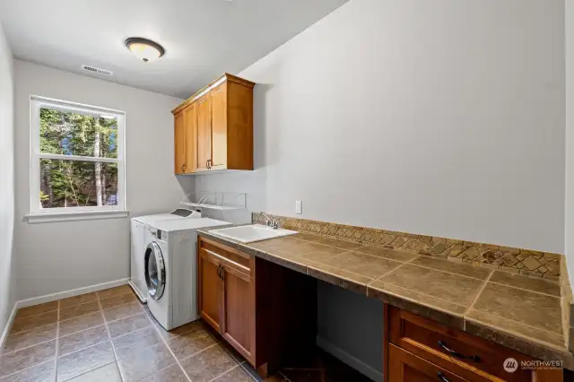 Upstairs laundry room with utility sink and folding table