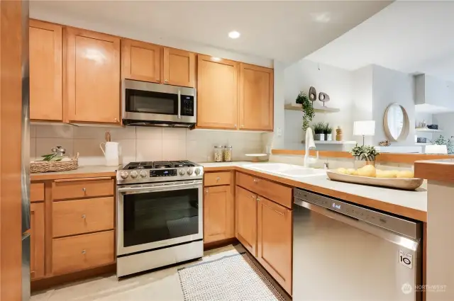 Wonderful kitchen with gas cooking, stainless steel appliances and plenty of counter and lovely wood cabinets for storage plus raised eating bar.