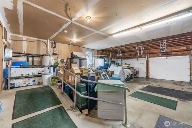 Inside of attached 2 car garage,  Concrete ramp leads into the house. Generator with separate panel stays.