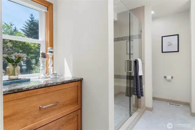 Primary bathroom & walk-in closet fully updated with beautiful pecan cabinetry, tile & quartz. Views of the garden!