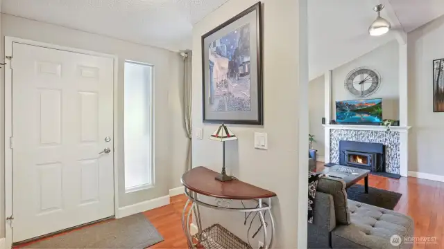 Walk into warm hardwood floors and a welcoming entry area with room to personalize, offering direct access to the living room—complete with space for a console table and décor