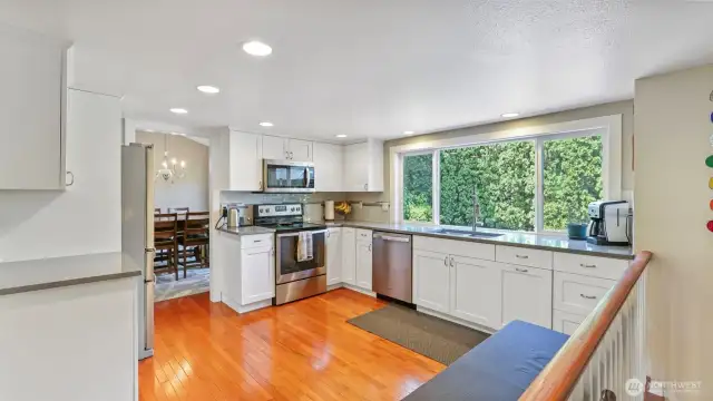 Sleek white shaker cabinets pair with generous natural light to create a crisp and inviting culinary space