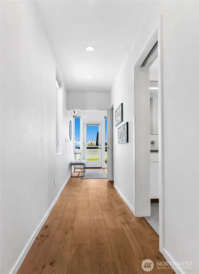 Flow with intention. This central hallway connects the private primary suite with terrace access, spa-like bath, and walk-in closet—showcasing the calm, curated layout of the entire upper level.
