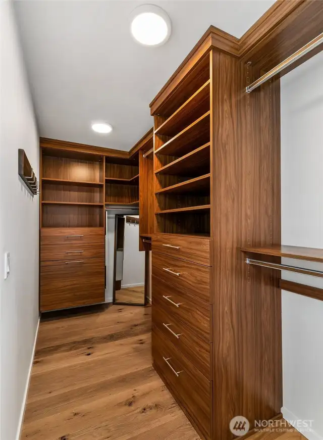 Tailored storage, timeless materials. The custom walk-in closet pairs clean design with natural wood finishes—offering refined functionality and a sense of calm in the everyday routine.