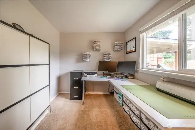 Currently utilized as a creative workspace, this third bedroom offers ample space and flexibility to suit your needs—whether it’s a home office, craft room, or traditional bedroom. The generous window overlooks the backyard, providing great natural light for any setup.