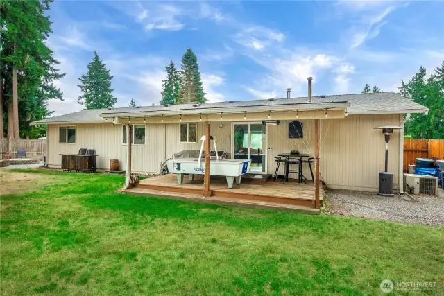 Enjoy the benefits of a covered back patio—ideal for year-round relaxation or entertaining. The string lights add a cozy ambiance, while the spacious wood deck offers plenty of room for outdoor seating, dining, or recreation. Just off the deck, the large, level backyard provides green space for pets, play, or gardening.