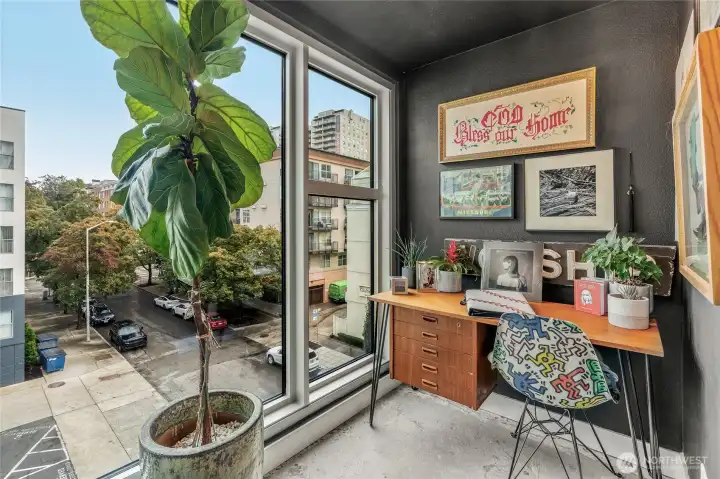 Dedicated office nook with floor-to-ceiling windows — separate from the living area.