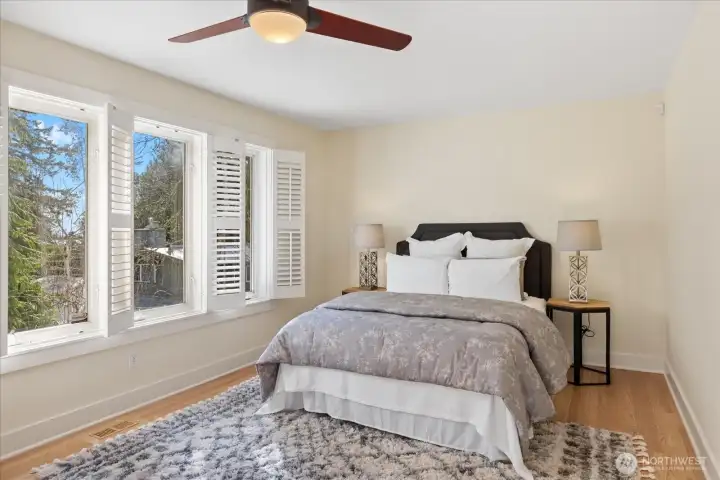 Primary bedroom retreat that showcases the room's openness and brightness. Plantation shutters offer versatility and convenience.
