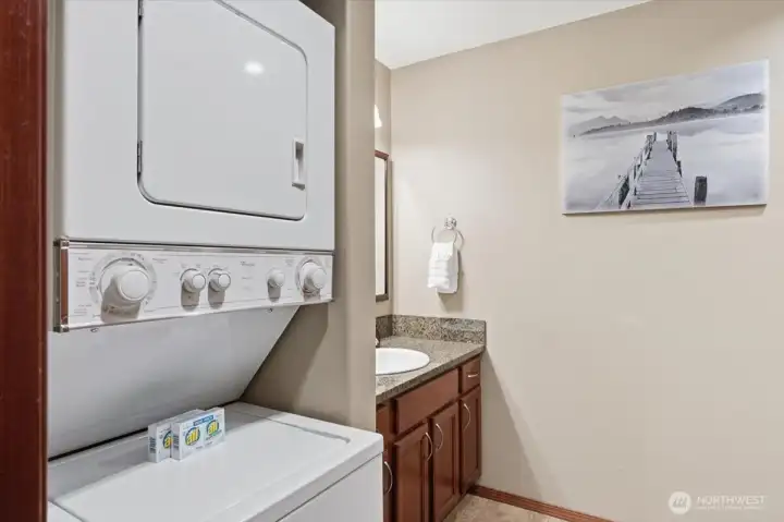 Dedicated laundry setup with stackable washer and dryer enhances long-term usability and convenience.