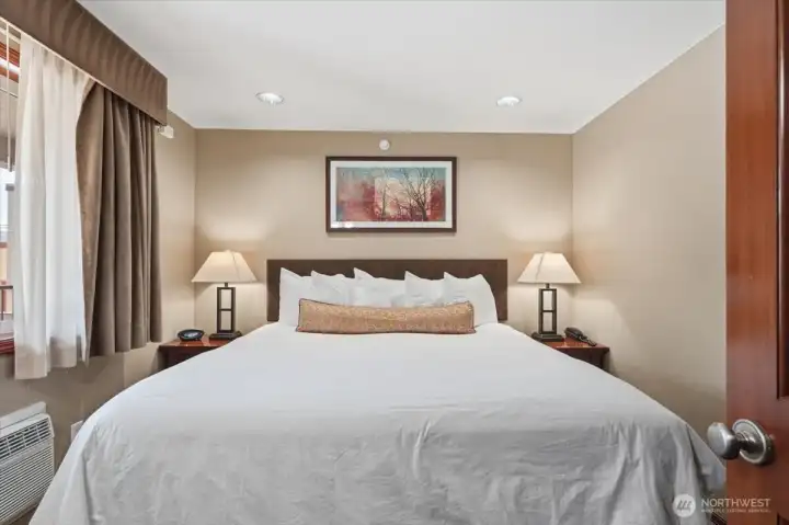 Spacious primary suite featuring a large king-size bed designed for comfort and relaxation.