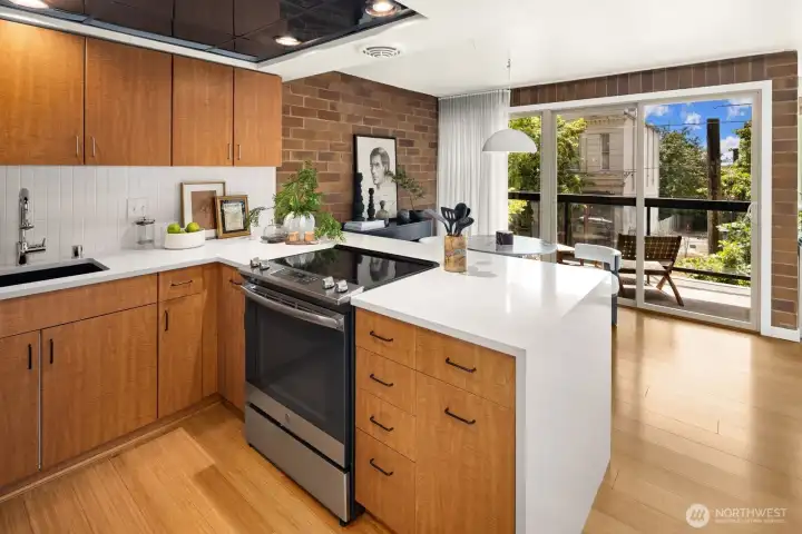 The heart of the home—an updated kitchen that opens seamlessly to the dining area and private covered balcony beyond.
