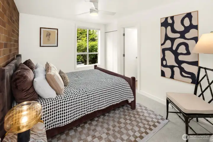 End the day in a peaceful primary suite featuring brand-new carpet, a timeless exposed brick accent wall, and a leafy outlook that brings the outdoors in.