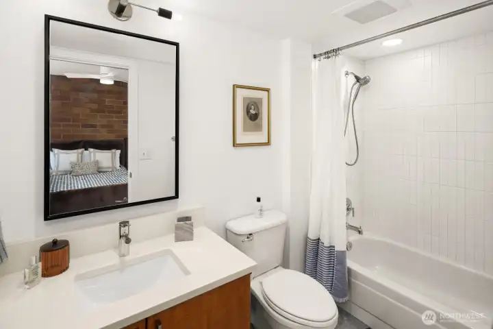 The beautifully remodeled en-suite bath features crisp, vertical subway tile and contemporary finishes that elevate your daily routine.