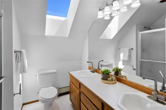 A gorgeous, naturally lit 3/4 bathroom with double vanity up on the topmost floor.