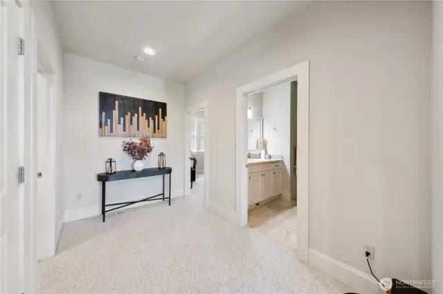 Down the hall from the living room and kitchen.  Primary suite is to the right!