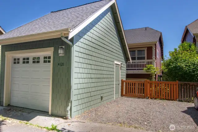 Detached garage with an extra parking pad offers flexible options for storage and vehicles.