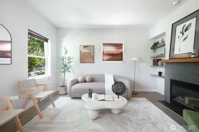 You're welcomed into a bright, serene living space with large windows and a cozy fireplace.
