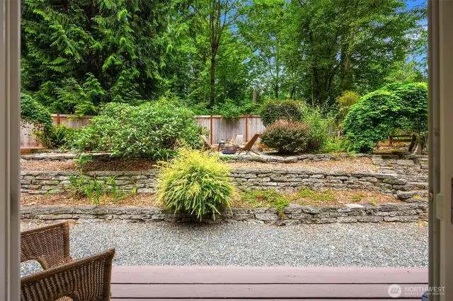 The partially fenced and private yard has multiple spaces for gardening and outdoor activities.
