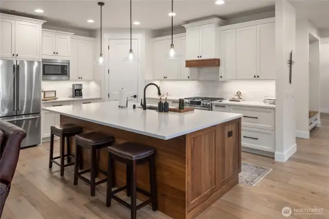 Stunning walnut island with quartz countertops are the star of this space for sure!