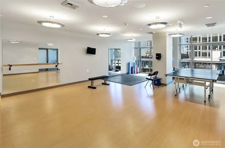 Flex room with barre area, stretching mats, medicine balls, rollers, ping pong table