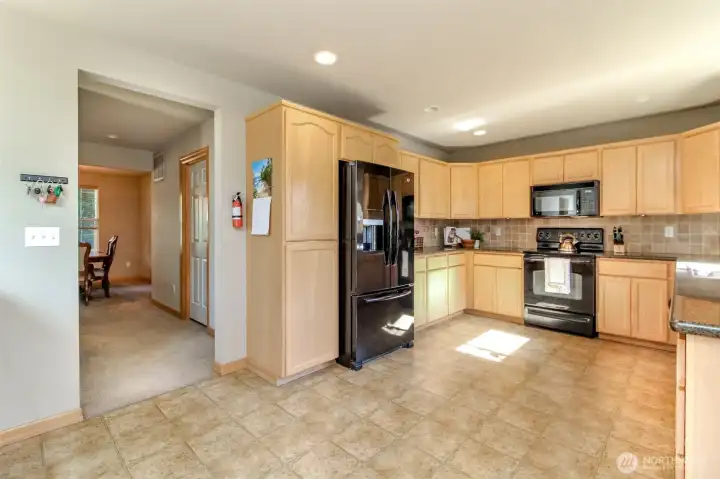 As you pass through the kitchen, the utility room is the door to the right and follows through to the garage. There is a half bath to the left, across from the utility room.