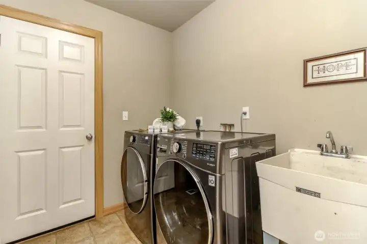 Utility room with laundry tub/sink. The door leads to the 3 car garage.