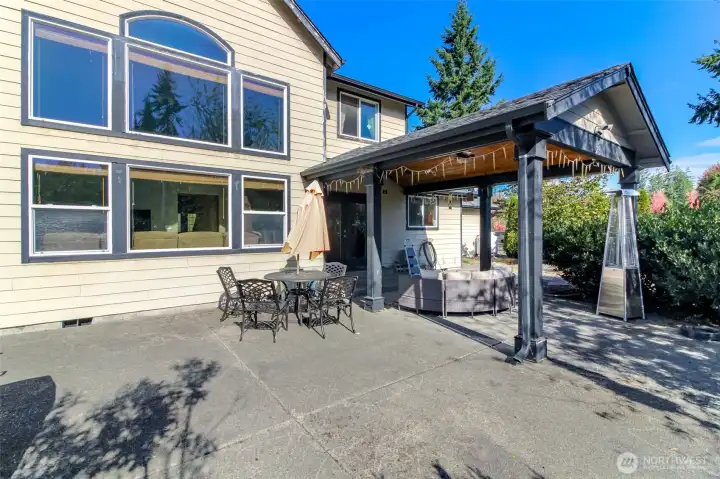 Large concrete patio and picture windows facing in the family room.