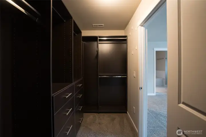 Primary suite closet is completely outfitted with custom storage...
