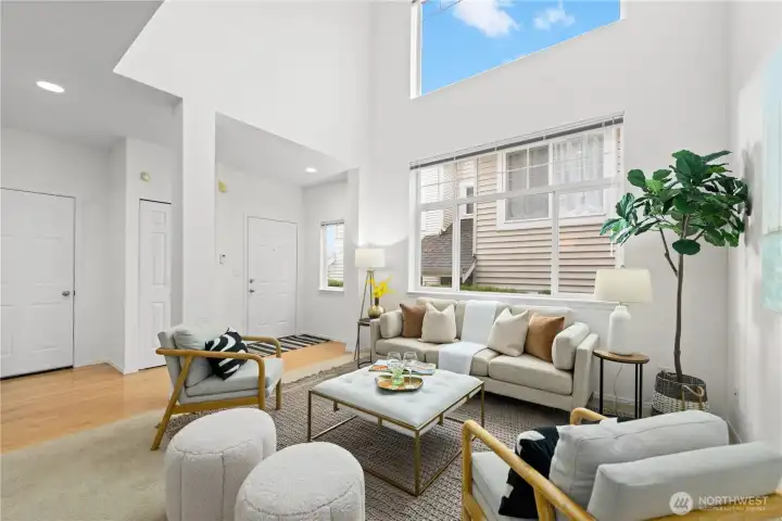 Living room with floor- to -ceiling windows and dramatic cathedral ceiling.