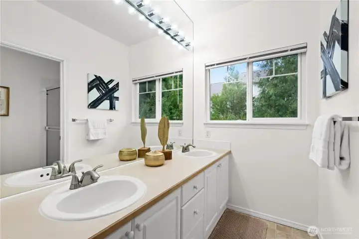 Primary 3/4 bathroom with dual sinks and a large walk-in closet.