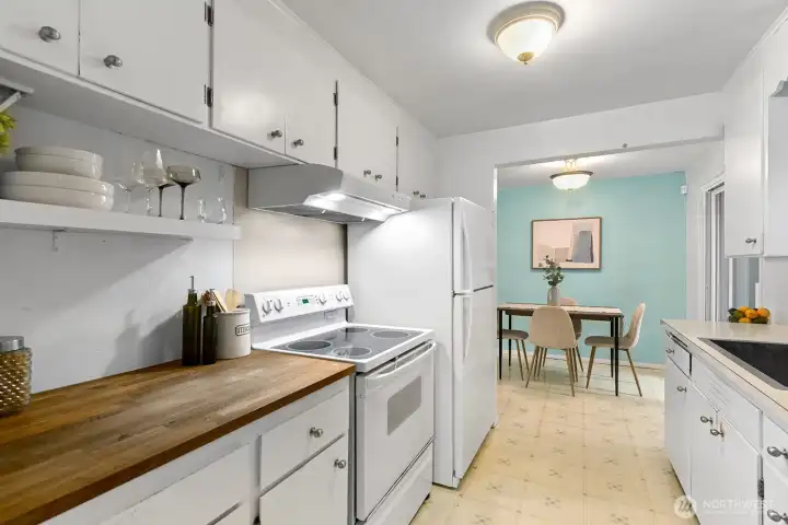 The kitchen has a cute built-in shelf for your bar ware and a butcher countertop.
