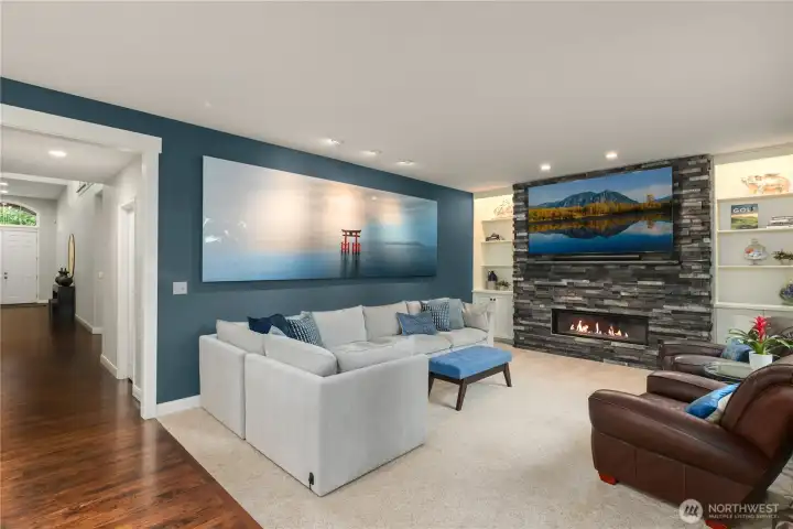 Relax around the fireside in the comfy family room with custom cabinets & library/media shelving.