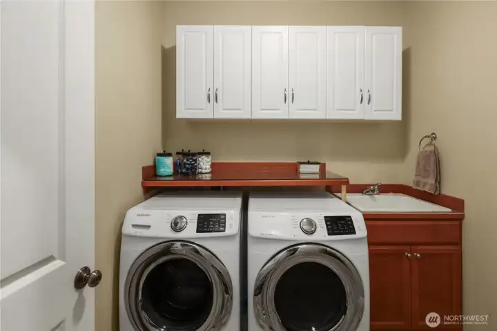 Laundry day is a breeze with built-in cabinets, shelving, & utility sink.