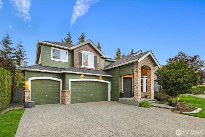 The attached 3-car garage features a recently upgraded door, epoxy flooring, & EV charger.