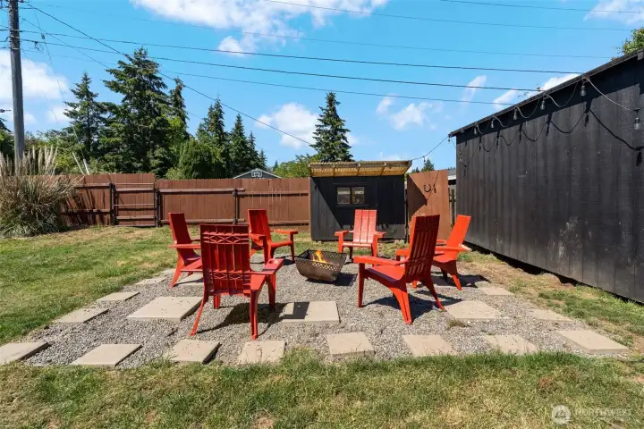 fire pit behind the firepit is the fenced are for a dog run or chicken run