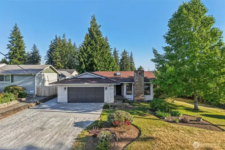 Front of the home with new driveway and mature landscaped front yard