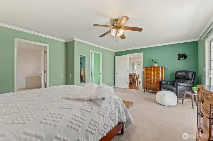 Primary bedroom with door to deck on right, door to WIC and bath on right. Center door to kitchen/dining.