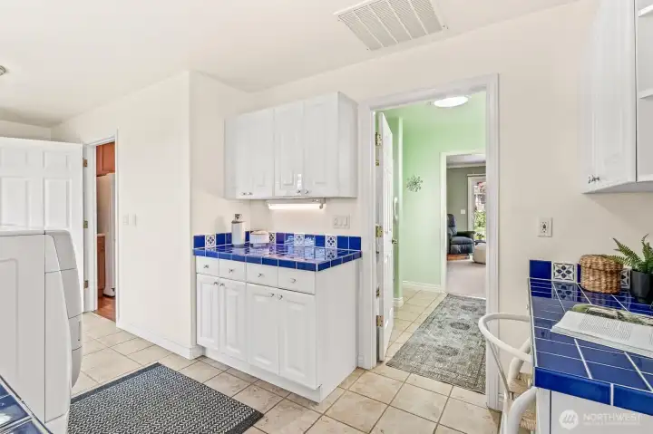 Utility room with view into primary bath.