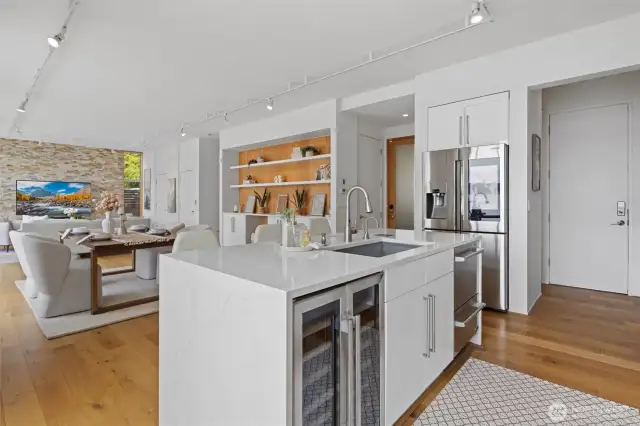 The open-concept layout is flooded with natural light, framed by floor-to-ceiling windows that showcase sweeping southwest views—sparkling lake waters.