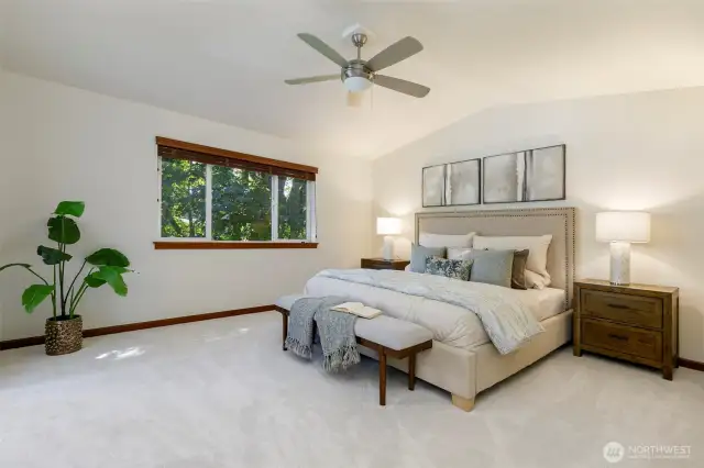 Primary bedroom with vaulted ceilings and fan