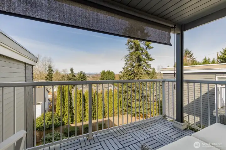 Relax on the deck featuring updated patio tiles and a retractable sun shade for hot summer afternoons