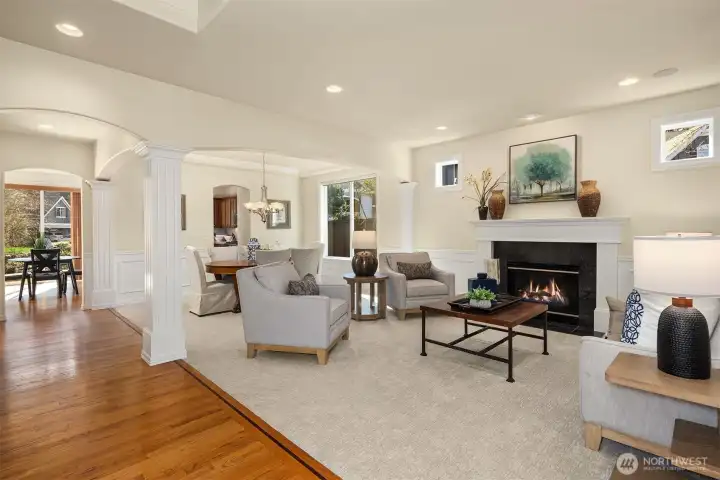 Another view showcasing the seamless flow between the formal living and dining rooms — notice the architectural arches and columns.