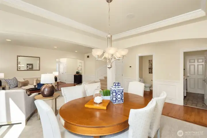 The formal dining room charms with architecturally interesting details including a tray ceiling, arches, and columns.