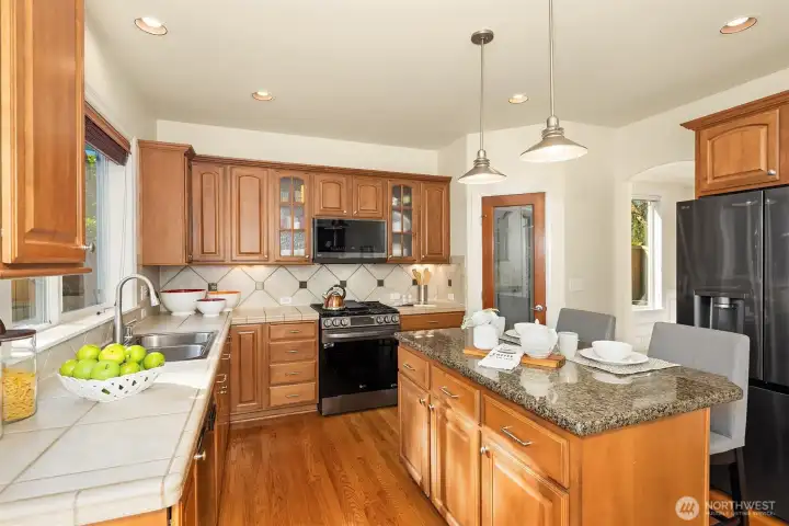 The kitchen features new (2024) smart LG appliances and a walk-in pantry — plus a built-in central vacuum with a convenient toe kick dustpan right on the island.