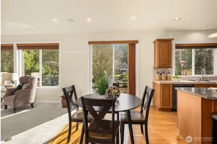 Sun-drenched casual dining with tranquil greenbelt views and slider access to the backyard.